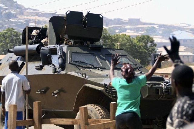 Appreciative Nigerians wave to a soldier inside an Otokar Cobra APC